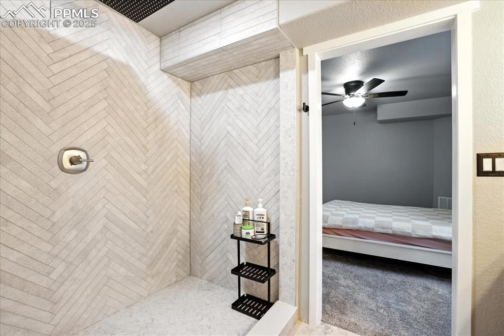 Full bathroom featuring ensuite bath, tiled shower, and a ceiling fan