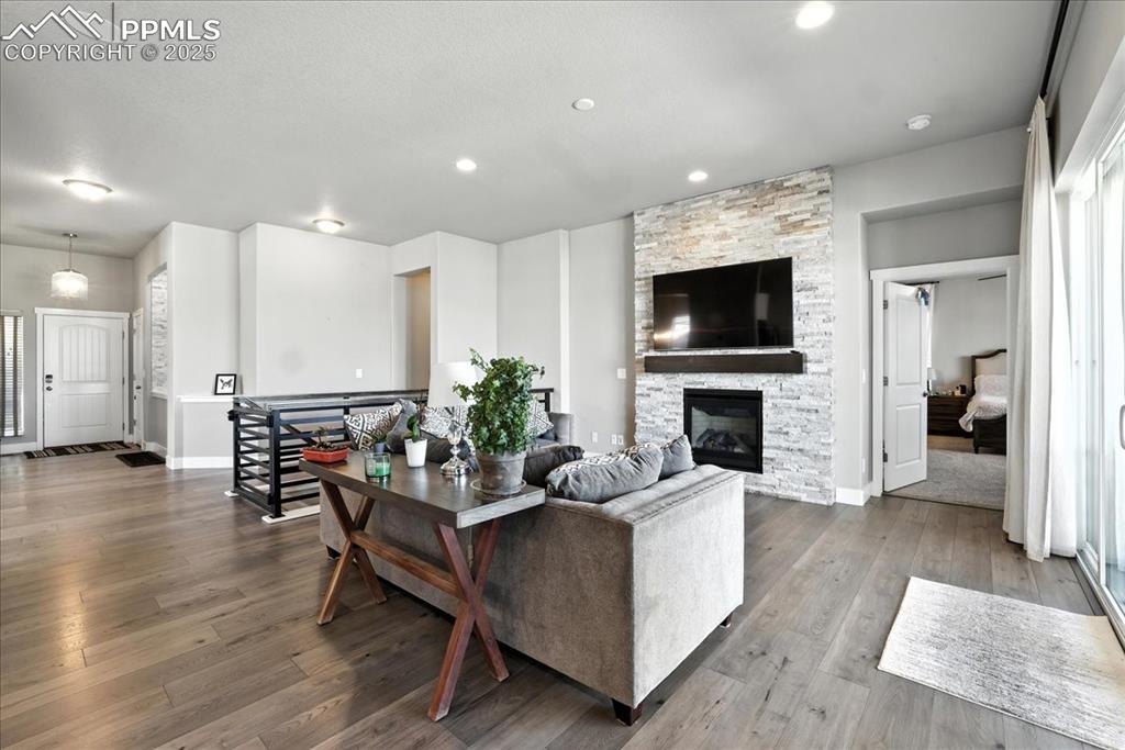 Living area featuring dark wood finished floors, a fireplace, and recessed lighting