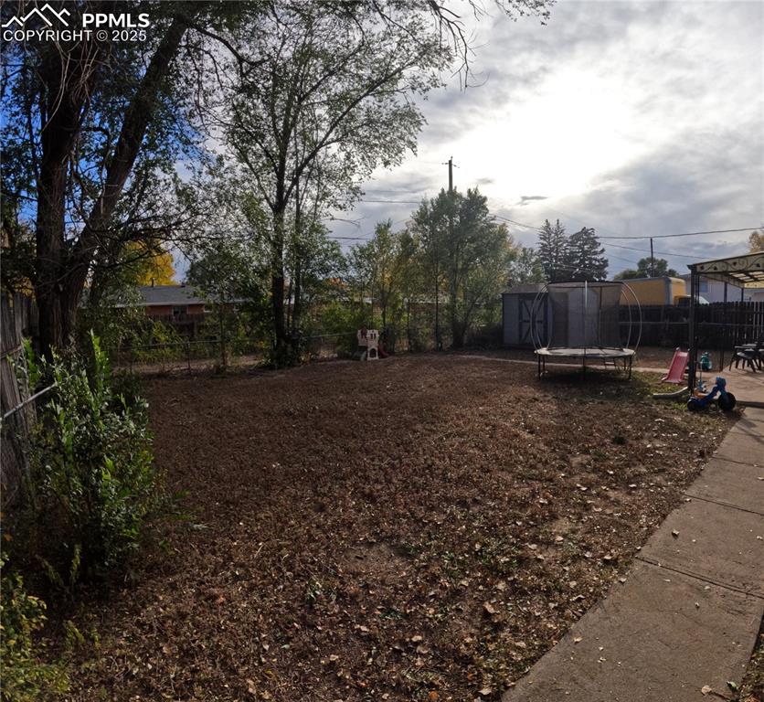 Fenced backyard with a trampoline