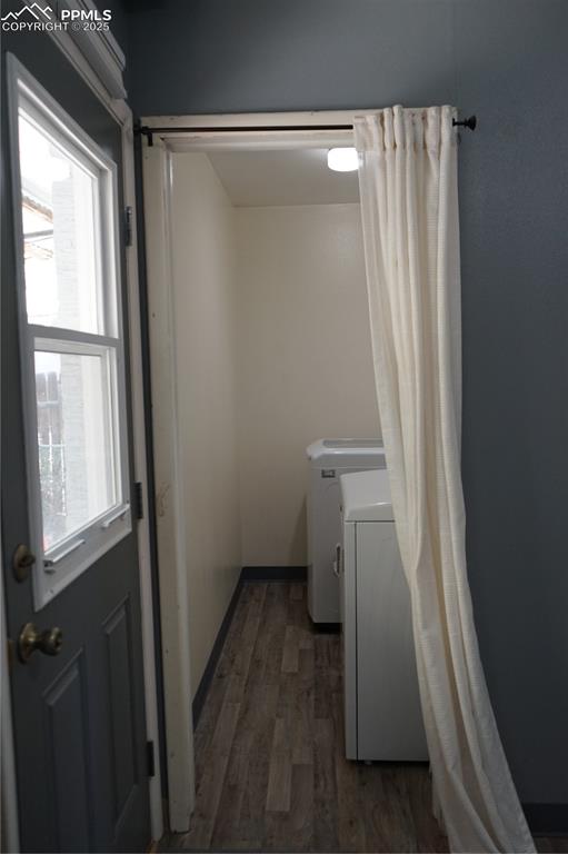 Washroom with dark wood-style flooring and separate washer and dryer