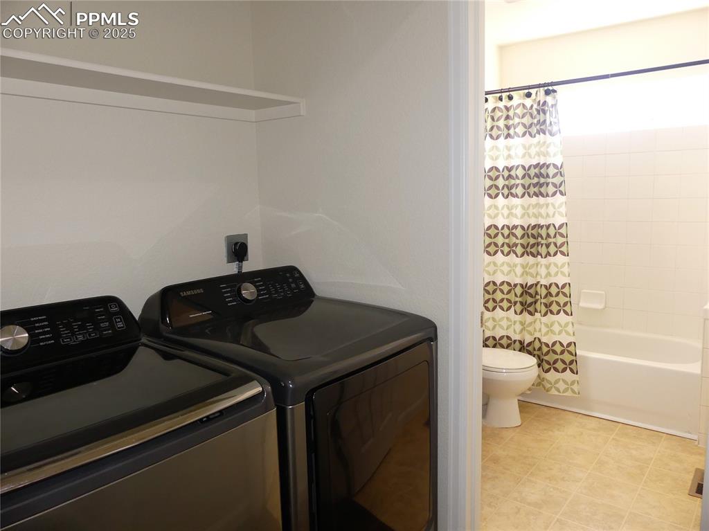 Laundry room featuring separate washer and dryer, laundry area, and light tile patterned floors