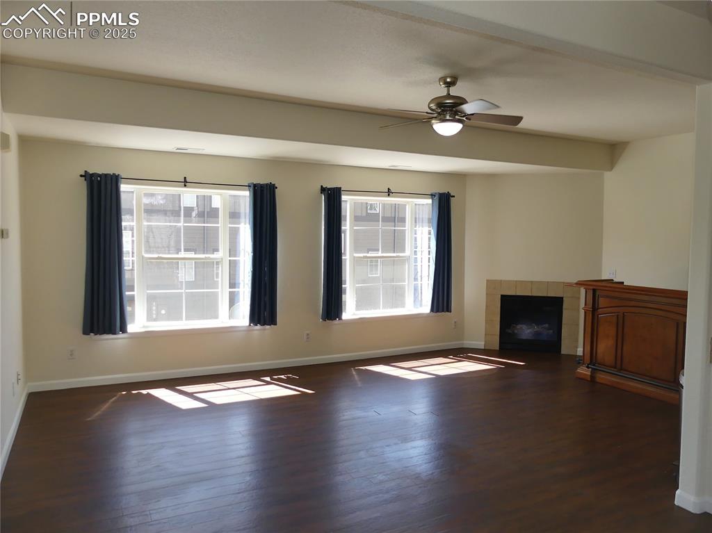 Unfurnished living room with baseboards and wood finished floors