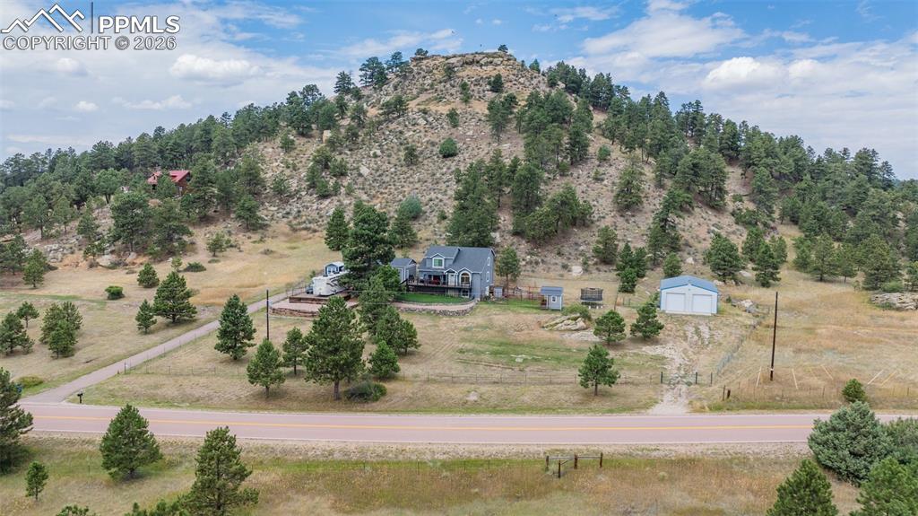 Good aerial overview of the entire property showing the paved driveway, fenced areas, outbuildings and updated home.