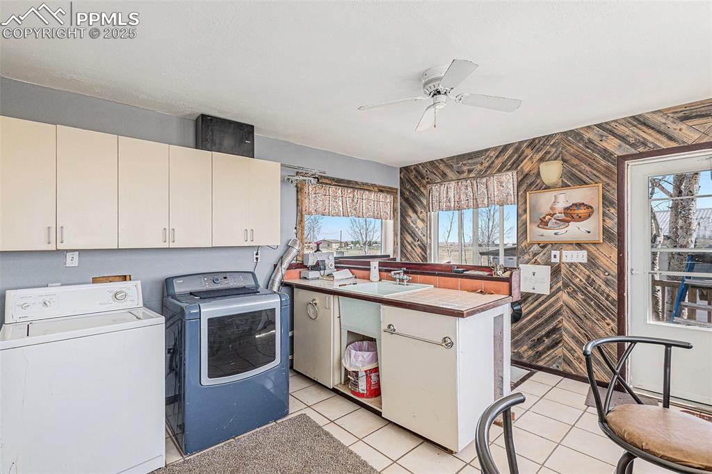 Washroom with a sink, a healthy amount of sunlight, ceiling fan, and washing machine and clothes dryer