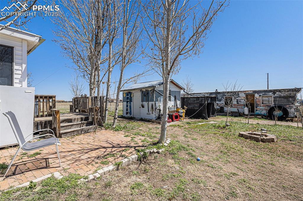 View of yard featuring a storage shed, fence, and an outbuilding
