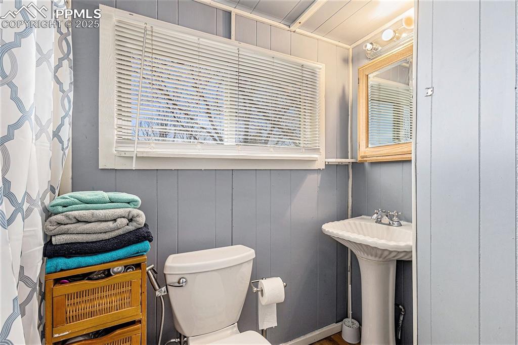 Bathroom featuring a decorative wall and toilet