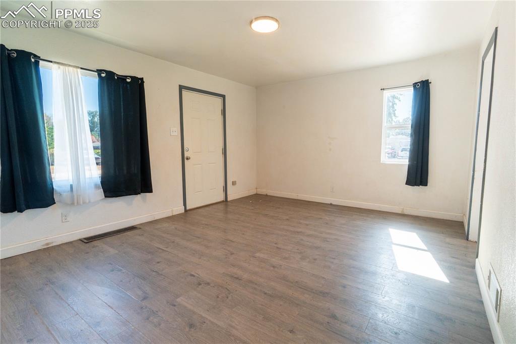 Unfurnished bedroom with hardwood / wood-style floors and baseboards