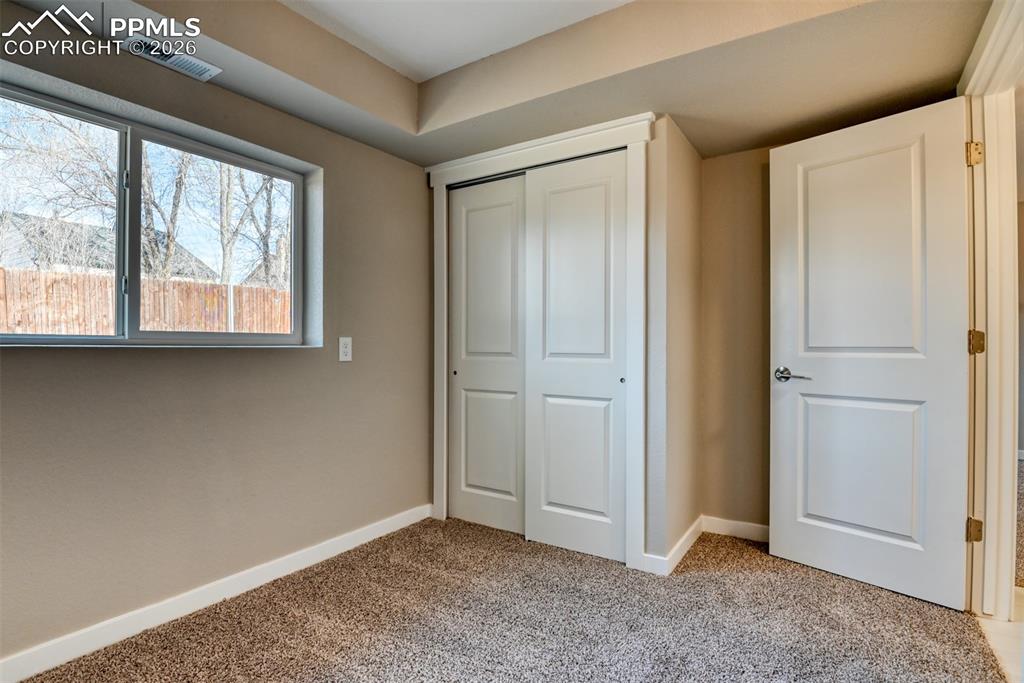Unfurnished bedroom with light colored carpet and a closet
