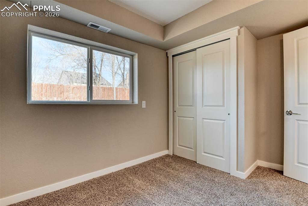 Unfurnished bedroom with light carpet and a closet
