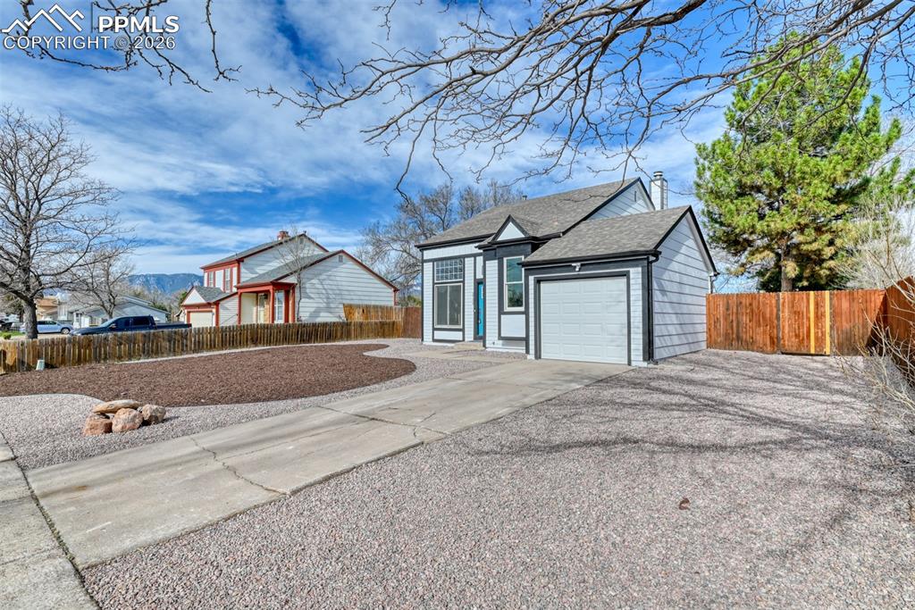 Single story home with concrete driveway, a garage, and roof with shingles