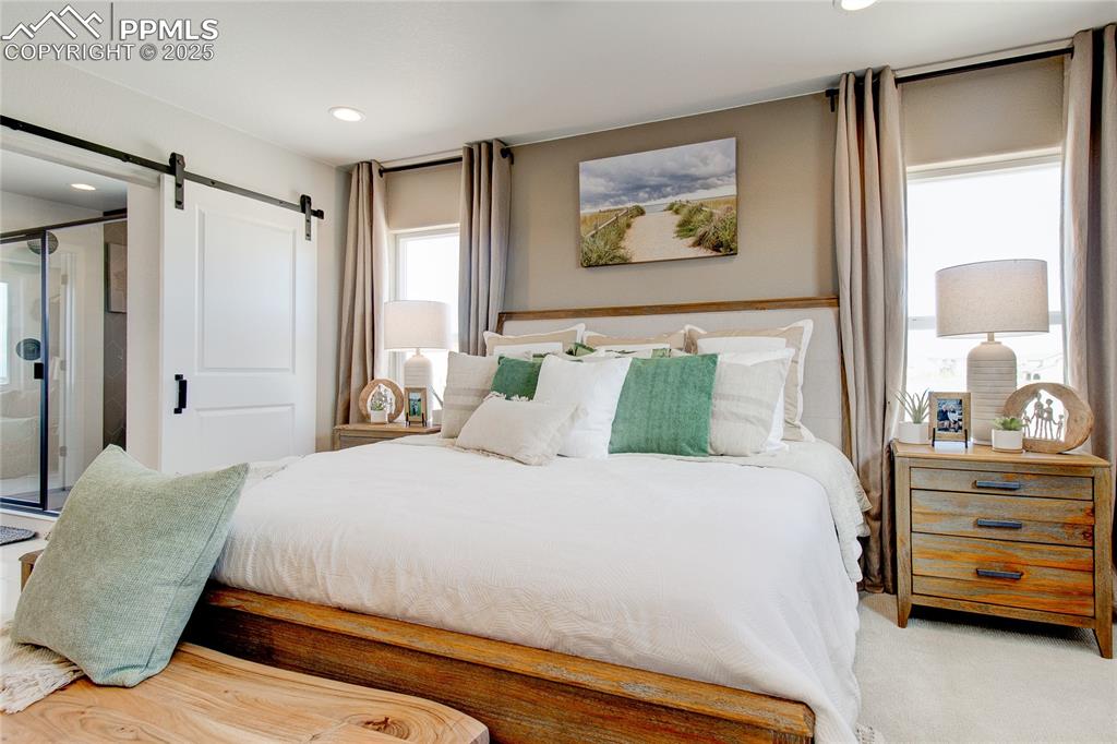 Bedroom featuring a barn door, recessed lighting, and carpet floors