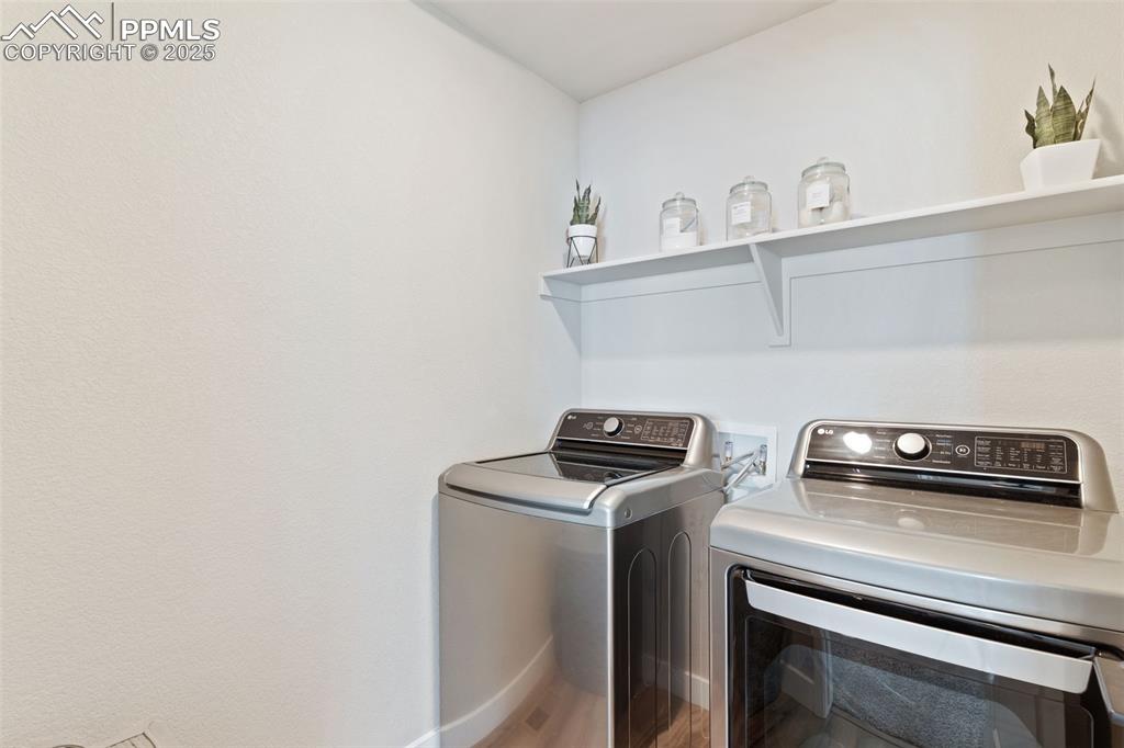 Washroom with washing machine and dryer and wood finished floors