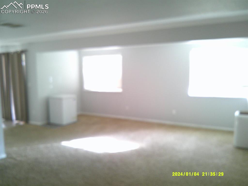 Carpeted spare room with baseboards