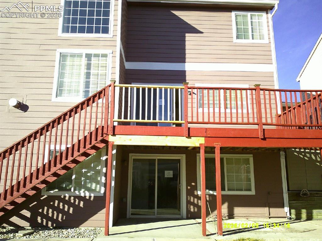 Rear view of house featuring a wooden deck and a patio area