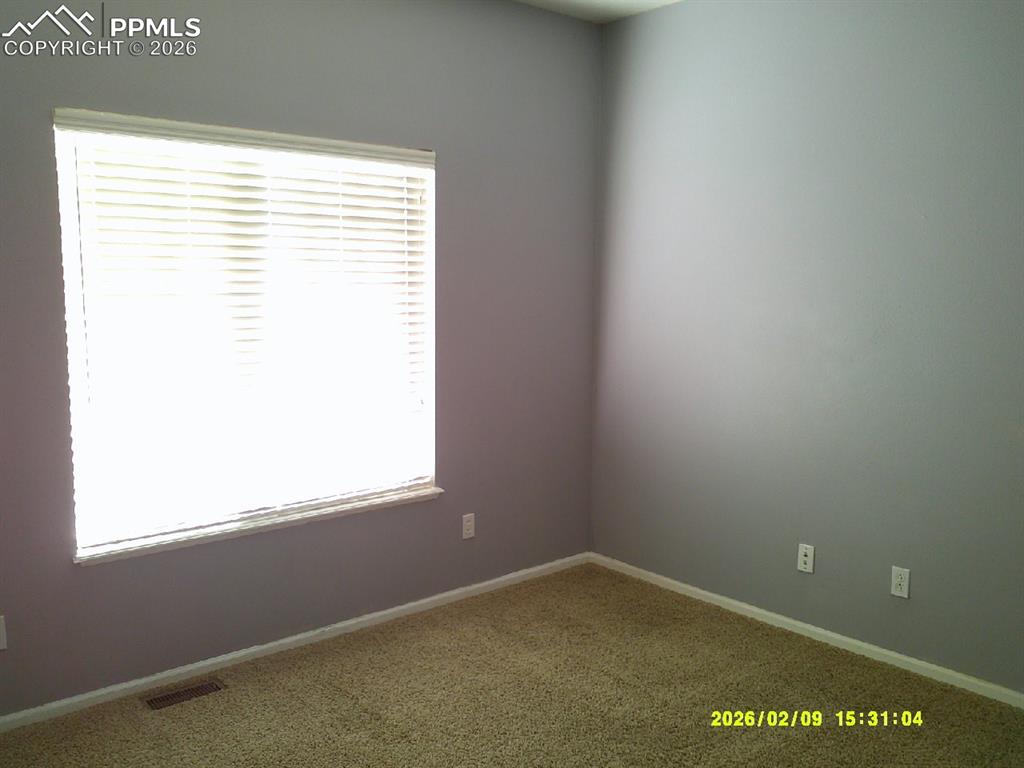 Unfurnished room featuring carpet and baseboards