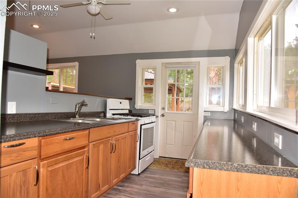 Kitchen featuring white range with gas cooktop, a sink, healthy amount of natural light, a ceiling fan, and recessed lighting