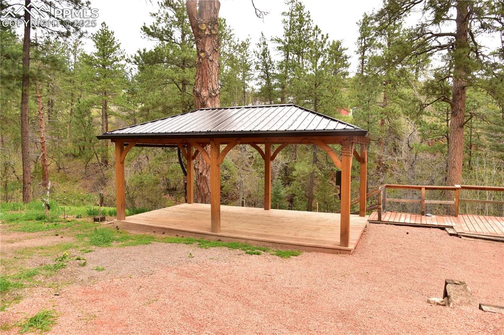View of yard featuring a deck and a view of trees