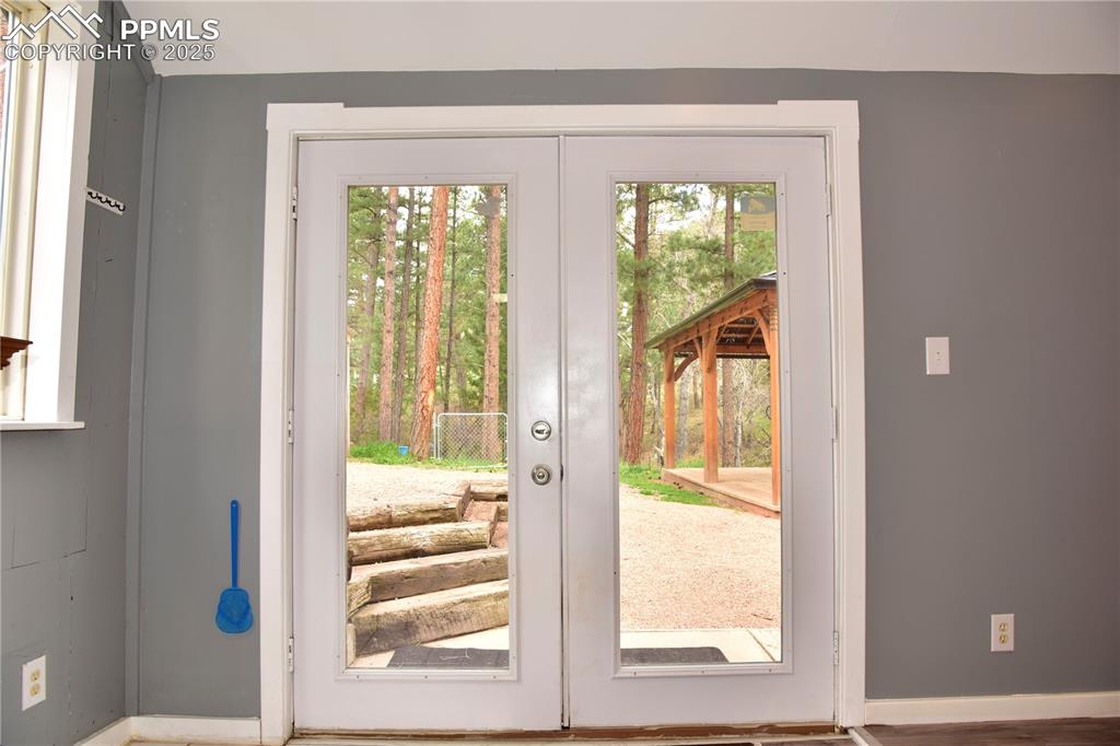 Doorway to outside featuring french doors and baseboards