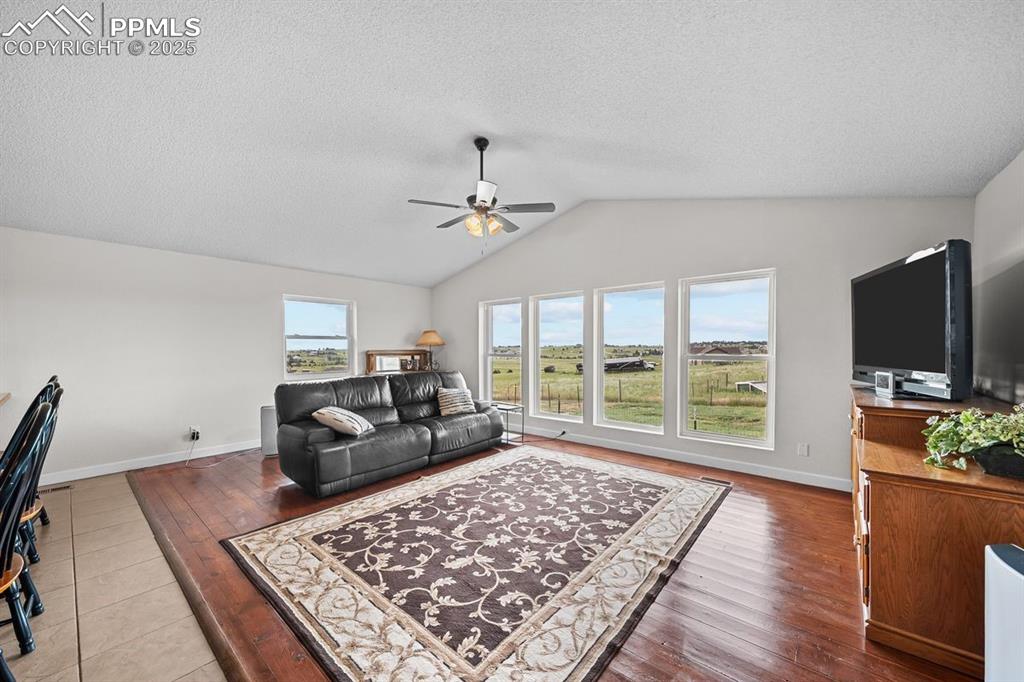 Living room featuring vaulted ceiling, wood floors, southern views and ceiling fan