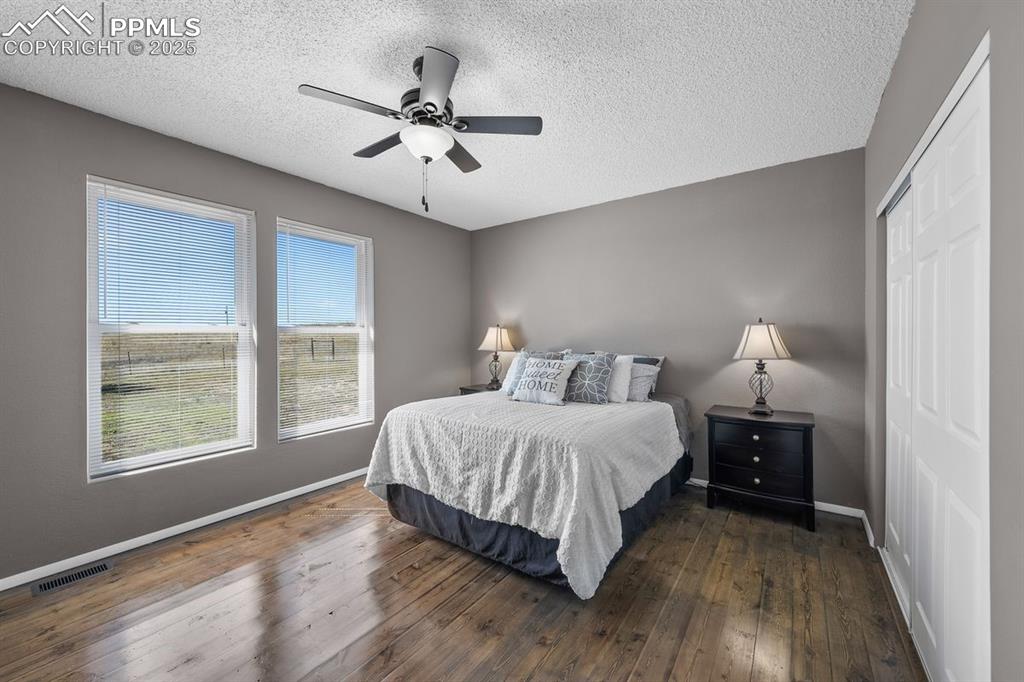 Bedroom featuring dark wood floors, a closet and ceiling fan