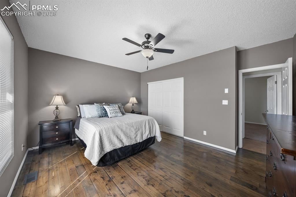 Bedroom featuring dark wood floors, a closet and ceiling fan