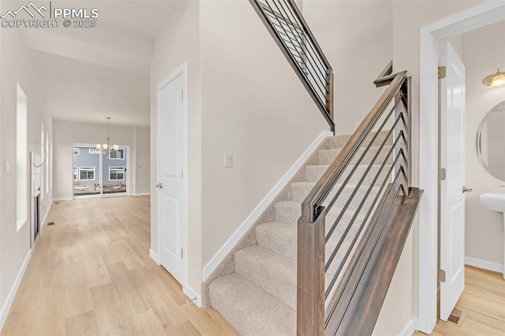 Staircase with a chandelier and wood finished floors