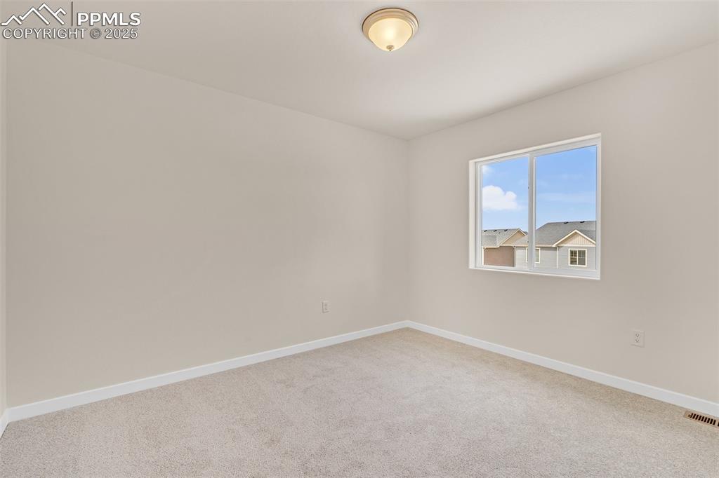 Spare room with light carpet and baseboards