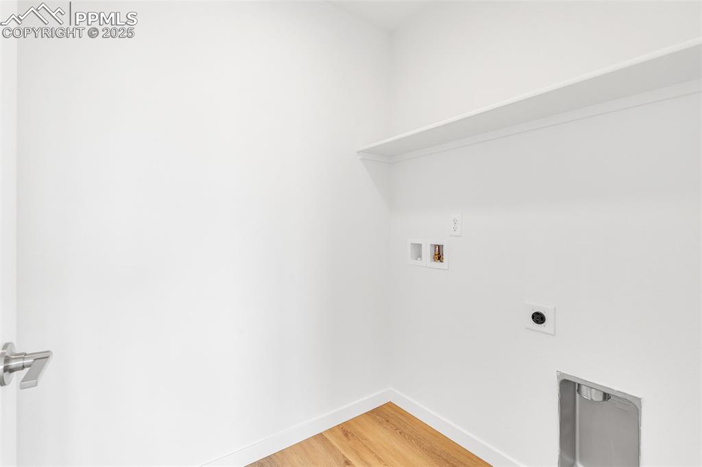 Washroom featuring light wood-style floors, hookup for a washing machine, and hookup for an electric dryer