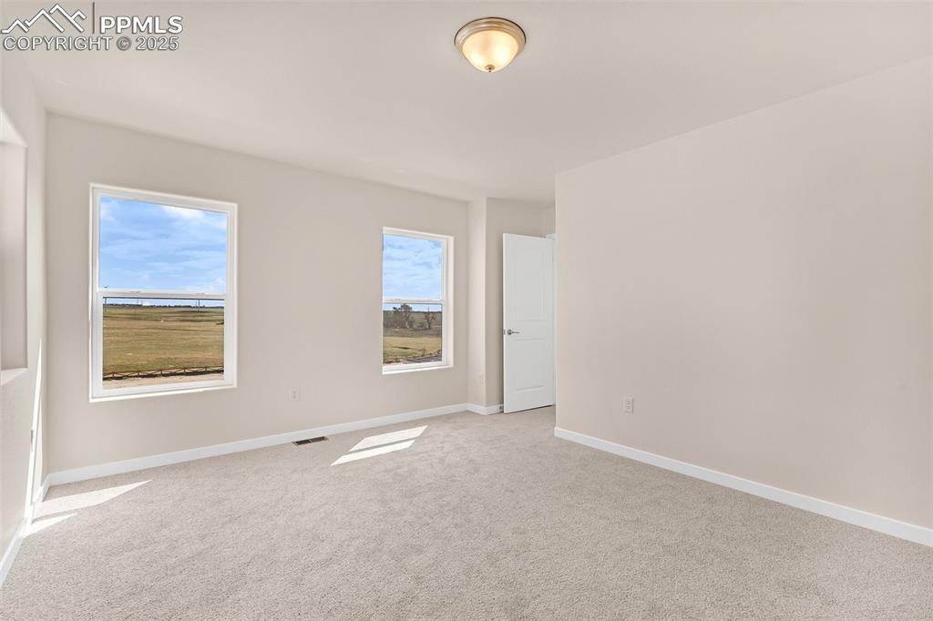 Carpeted empty room featuring baseboards
