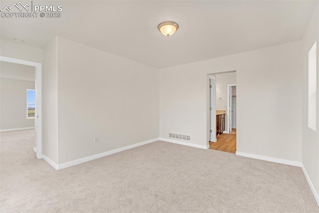 Unfurnished room with light carpet and baseboards