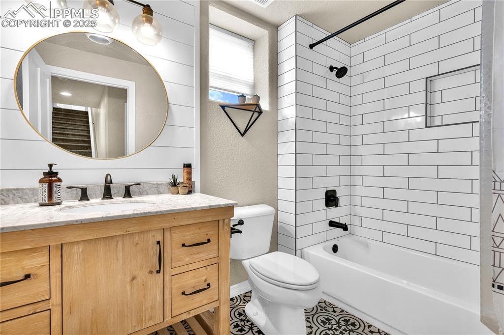 Full bathroom featuring vanity, shower / washtub combination, and a textured wall