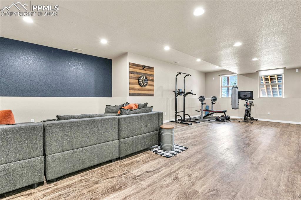 Exercise area featuring a textured ceiling, recessed lighting, and wood finished floors
