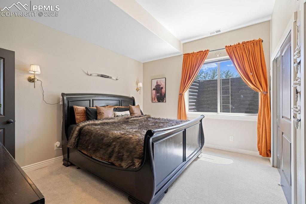 Bedroom with light colored carpet and a closet