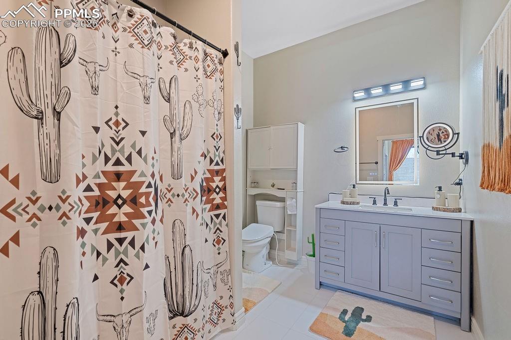 Full bathroom featuring vanity, a shower with shower curtain, and light tile patterned flooring