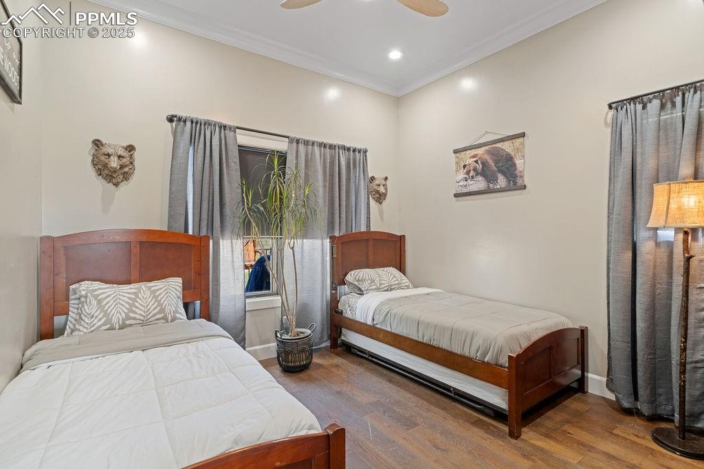 Bedroom featuring ornamental molding, wood finished floors, a ceiling fan, and recessed lighting