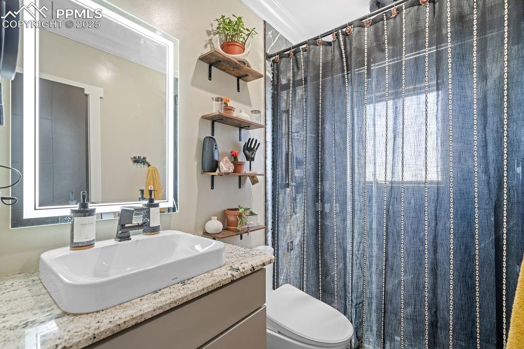 Full bath featuring a shower with curtain, vanity, and crown molding