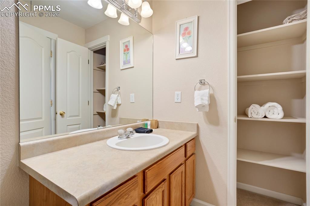 Bathroom with vanity and a spacious closet