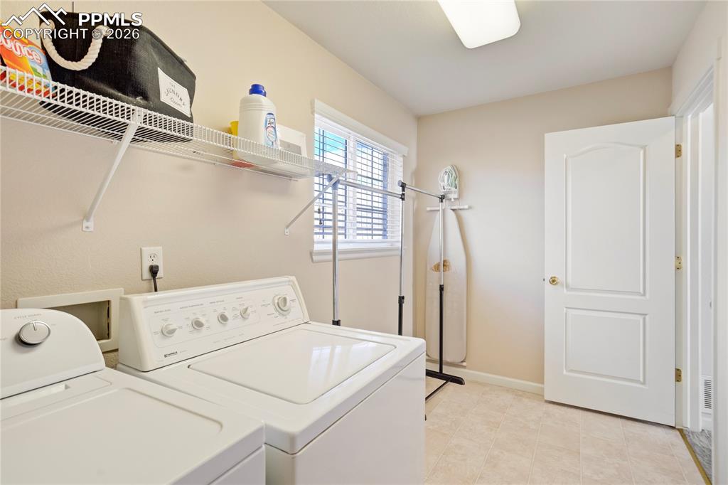 Laundry room featuring washing machine and clothes dryer and baseboards