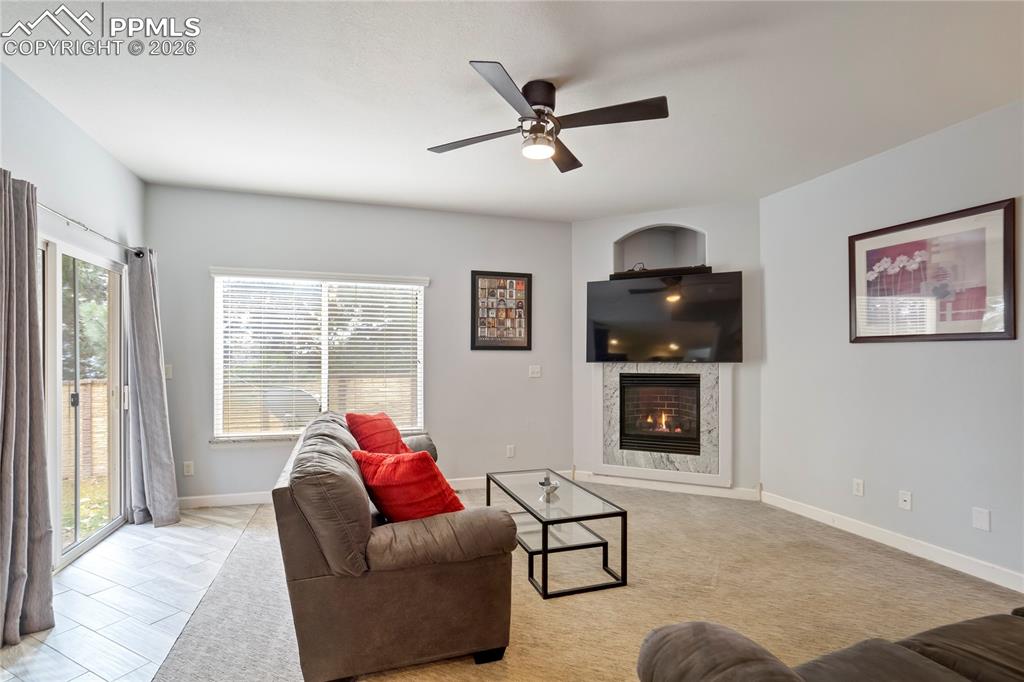 Living area featuring a fireplace and ceiling fan