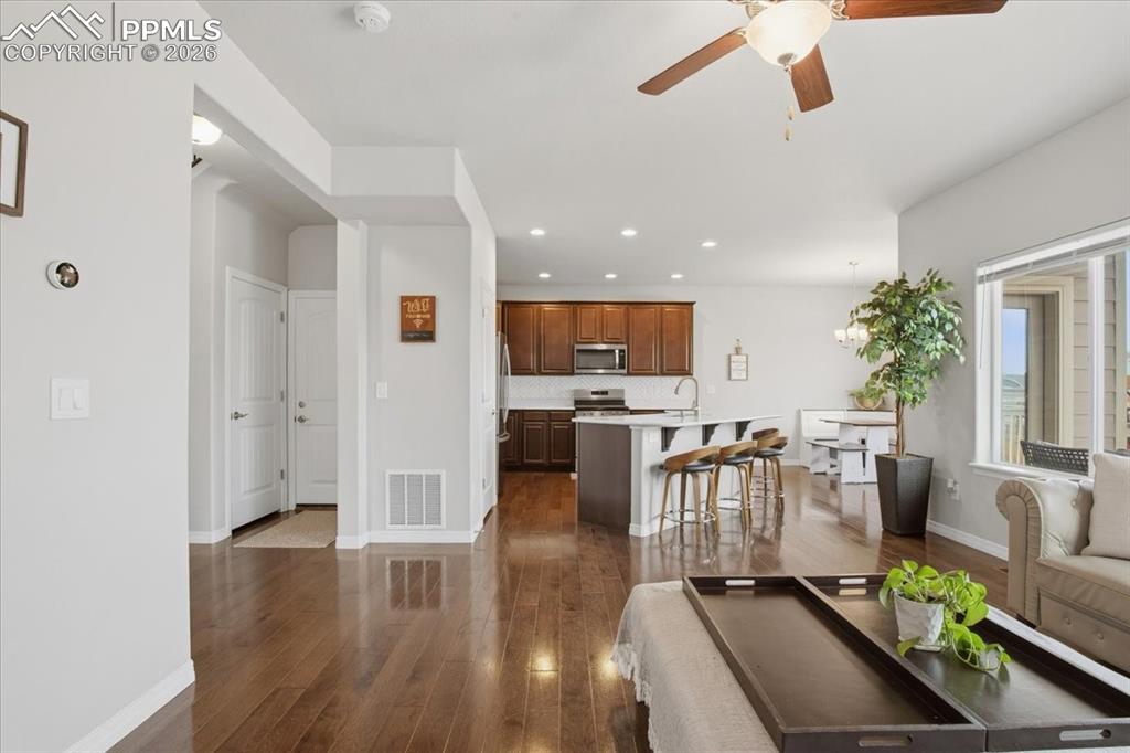Open concept living room with LVP flooring and ceiling fan 