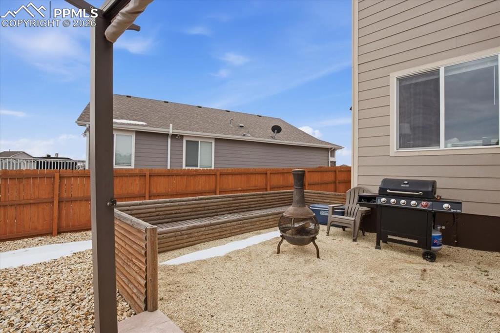 Custom built log seating area with wood burning fire pit and outdoor grilling space 