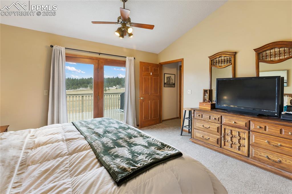 The main bedroom has a vaulted ceiling with a rich wooden beam and a ceiling fan, and enjoys direct access to the deck!