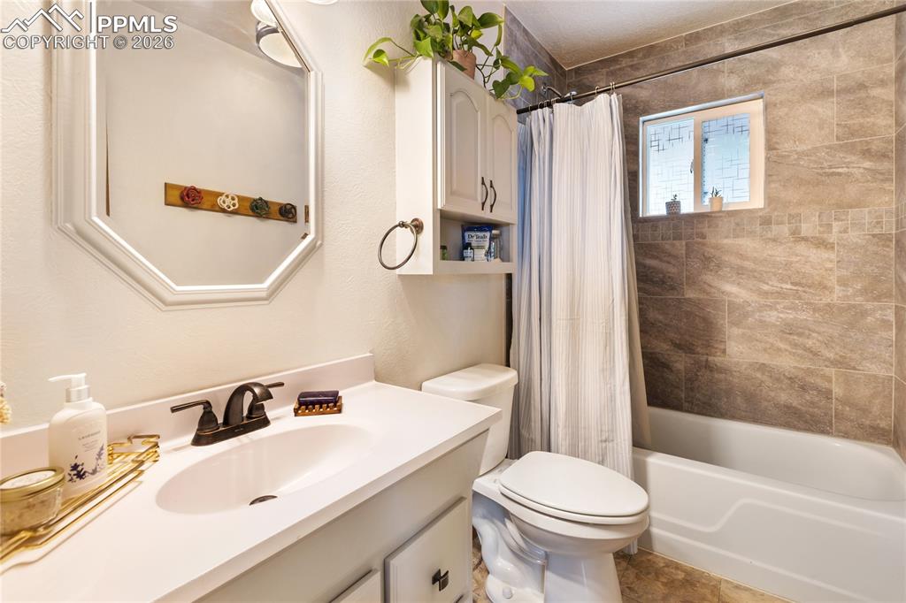 Full bath with vanity, shower/bath combination, and extra storage above the toilet!