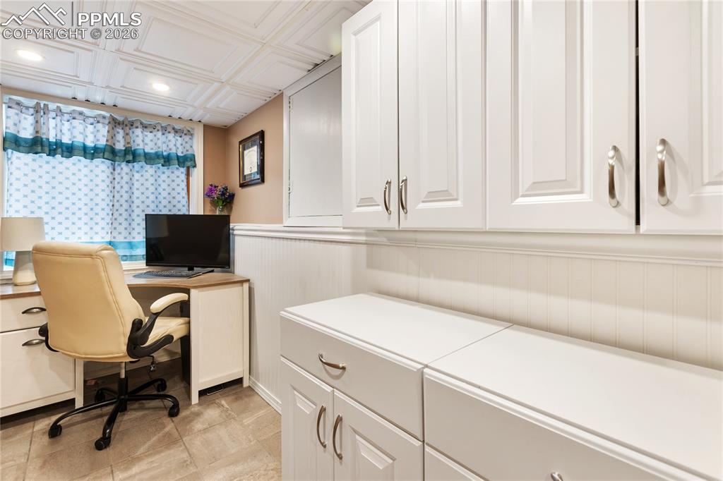 The laundry area overlooks the office, providing convenient visibility and flow between spaces.