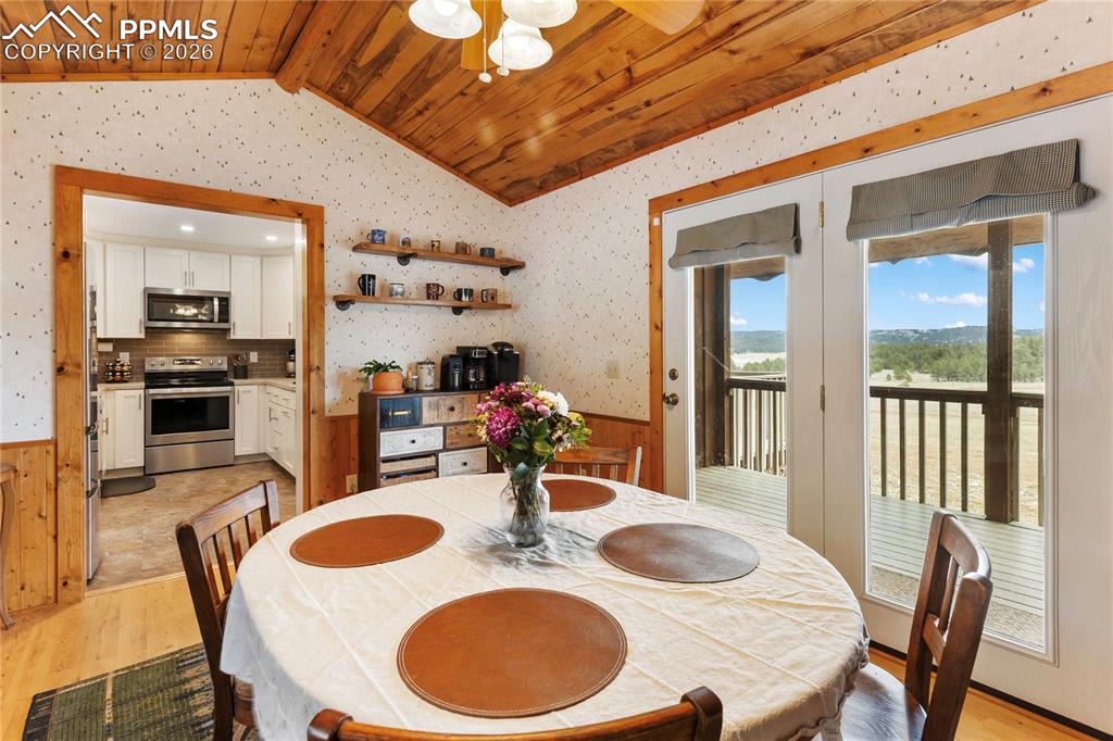 The walkout dining space has a wainscoted wall and a vaulted ceiling, finished with tongue-and-groove wood planks, and overlooks the kitchen!