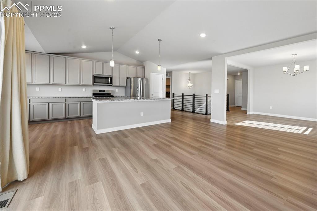 Open concept living, looking towards front door and stairs 
