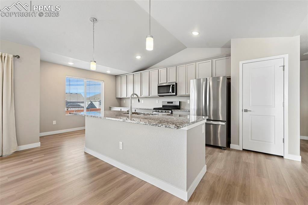 Designer kitchen with soft gray cabinetry, island, stainless appliances 