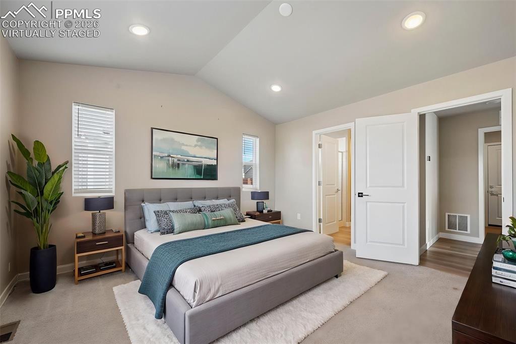 Virtually staged primary bedroom w/ ensuite on main floor 