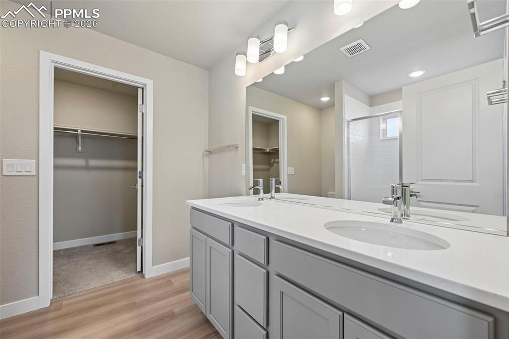 Primary bathroom with double vanity, shower and large walk in closet 