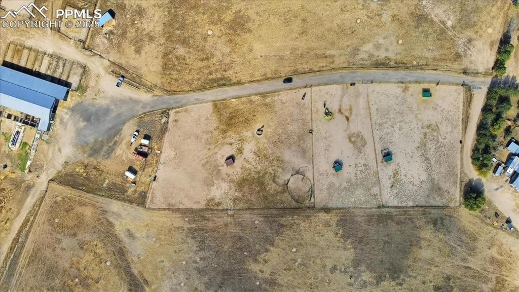 Arial view of road from the house to the barn. There are boarding paddocks, a large fenced field at the top of the photo, and owners field at the bottom of the photo